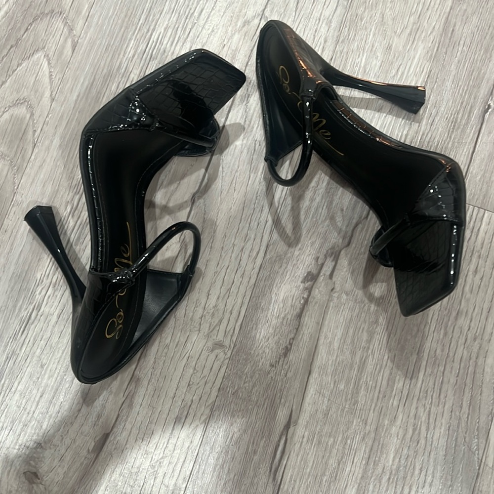 Black strapped faux leather heels.